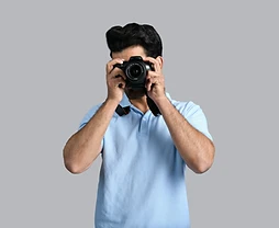 Photographer looking through a DSLR viewfinder during a portrait session in Taif