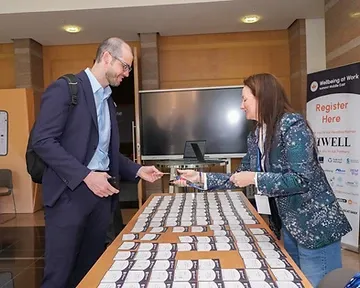 Conference registration desk with attendees collecting badges at an event in Riyadh