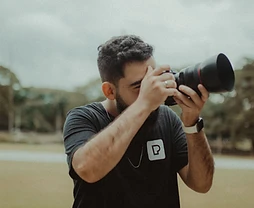 Professional photographer looking through a DSLR viewfinder outdoors in Riyadh
